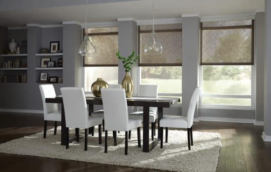 A dining room with Lutron motorized shades partially lowered over the windows.